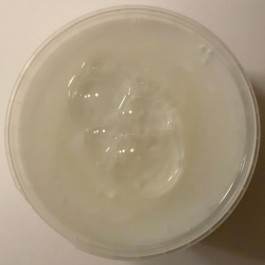 Dieses Bild steht für die Werkreihe Kartenhäuserkonstruktionen (Version Slime). Das Quadrat zeigt einen runden Behälter von oben in der maximalen Größe – das heißt auf allen vier Seiten stößt der Rand des Behälters fast an den Bildrand. In dem Behälter ist eine weiße Masse – Joghurt, oder eine Creme. Auf dieser Masse haben sich Blasen gebildet. Die Blasen haben sich in der Mitte gesammelt, sie drängen sich ineinander und bilden so eine neue Einheit. 